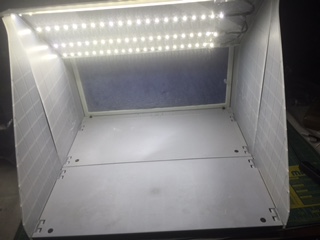 The fully lit airbrush spray booth with the LED light strips installed and powered on