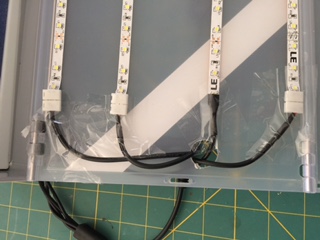 The LED light strips attached and the connectors taped down. You can also see the pass-through hole that I cut in the spray booth for the wires